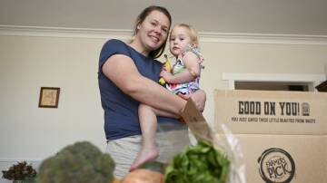 Jackie Walker, pictured with her two-year-old daughter Violet, has been subscribing to Farmers' Pick for a seasonal produce box for more than a year to help curb rising living costs. Picture by Lachlan Bence