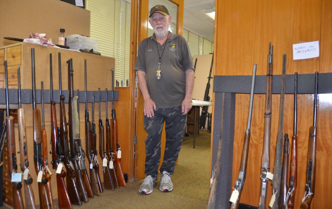 RIFLING THROUGH THE COLLECTION: Small Arms Factory Museum volunteer Kerry Guerin with firearms donated during the amnesty. Picture: PHOEBE MOLONEY.