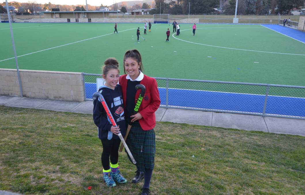 SISTERS WITH STICKS: Hannah Kable and her little sister Lily who also represented NSW at the Pacific School Games. Picture: PHOEBE MOLONEY. 