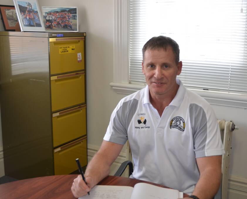 RETURN OF OSBORNE: Graeme Osborne with photographs from the Workies' premiership win in 2012. He will coach the premier side in 2018 after moving into junior development in 2016. Picture: PHOEBE MOLONEY. 