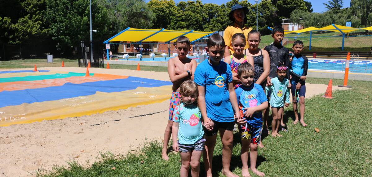 NO JUMPING FOR JOY AT THE POOL: Disappointed children in front of the damaged jumping pillow. Photo: Troy Walsh.