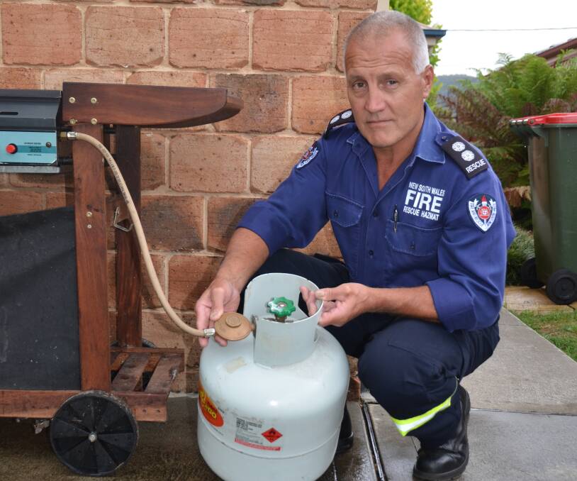 BBQ SAFETY: Lithgow station officer Noel Ford inspects the cylinder connection. More info: www.fire.nsw.gov.au/home-fire-safety/bbq.