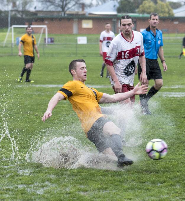 ATROCIOUS CONDITIONS: Workies' Nick Young tries to make the best of the sodden pitch. PHOTO: Alex Grant.