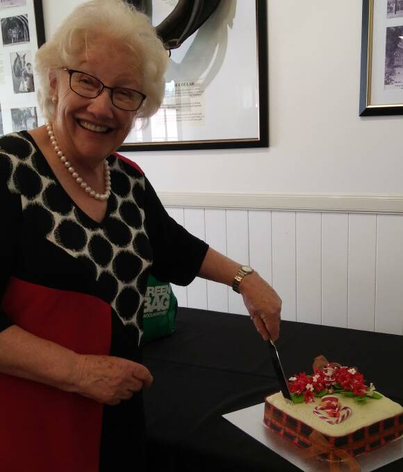 CELEBRATION CAKE: Beehive member  Jenny Barnes cuts the cake at the end of the year festivities.
