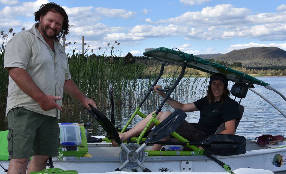READY TO GO: Trevor Evans and Matty Hunter with the boat designed and built to tackle the Murray River on pedal power. Picture: HOSEA LUY