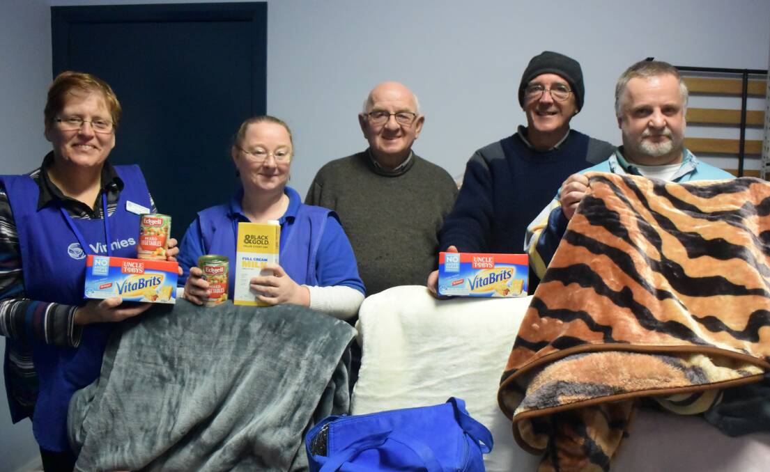 HERE TO HELP: St Vincent de Paul volunteers Allyn Jory, Wendy Hassen, Gary Marshall, Garry Manton and Bill Cook with a few essential items. Picture: HOSEA LUY
