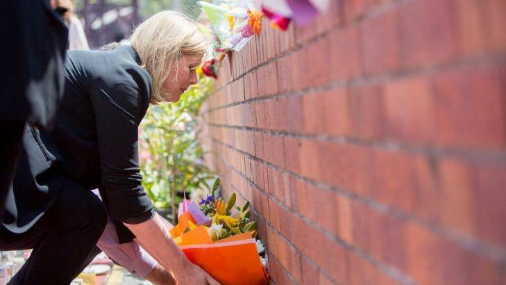 Ardent Leisure chief executive Deborah Thomas places flowers at the memorial at the Dreamworld gates Photo: Tammy Law