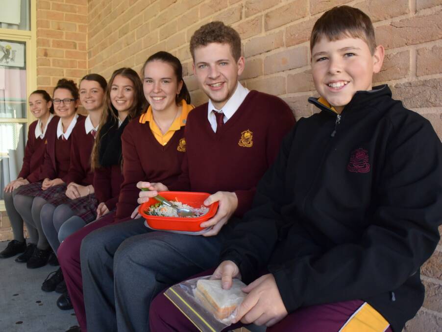 SMILING THROUGH IT: La Salle students Paige McNamara, Brielle Mendham, Grace Hadley, Hayley Bennett, Leah Phlillis, Dillan Thompson and Lachlan Zyp with (yum) white rice and white bread for lunch. 
