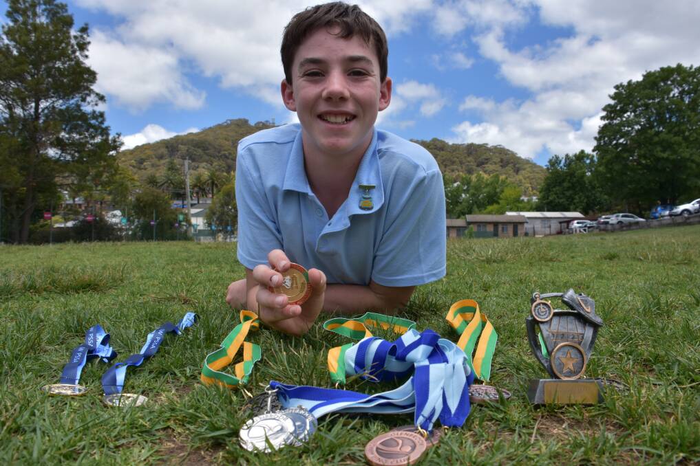 A COLLECTION: Year 5 student Angus Clues with his recent collection of medals gained on the field and in the pool. Picture: KIRSTY HORTON. 