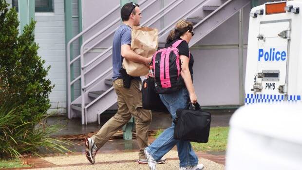 Detectives leave Port Macquarie police station with bags of evidence. Photo: Nick Moir