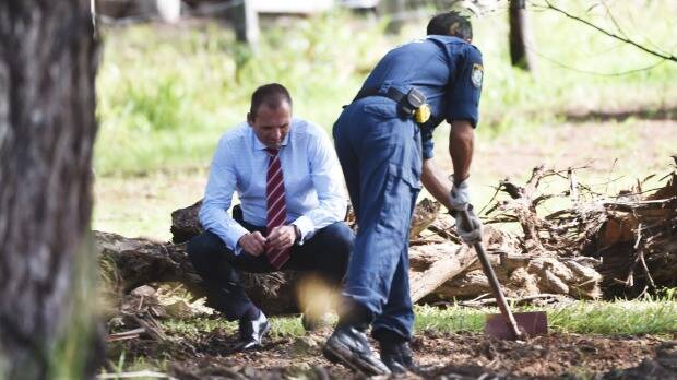 Police search the grounds of the semi-rural property in Bonny Hills. Photo: Nick Moir