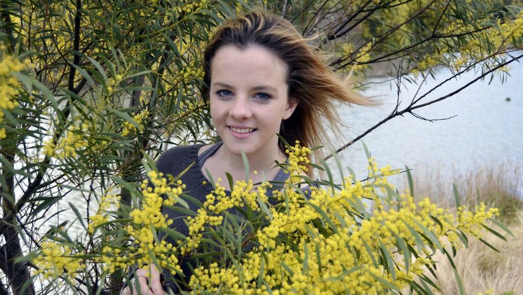 COLOURFUL: Seventeen-year-old Tennielle Collins of Lithgow looks a picture among the wattle that has sprung up around the district. You can find more about Tennielle next week when she featured in the Mercury’s Rage Page. lm092014wattle
