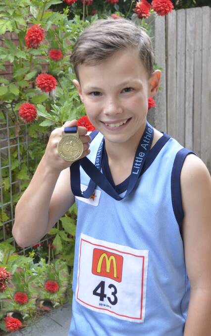 IT’S GOLD: Luke Thompson proudly shows off his state athletics
gold medal.