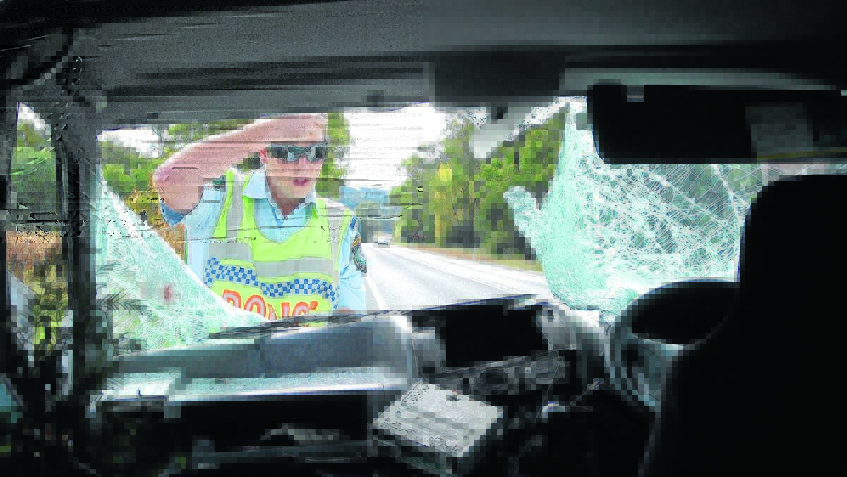 Police officer Trent Bright inspects the damage after a kangaroo cartwheeled through a van on Ulan Road in 2012. The NRMA is urging drivers to take care on the roads, listing Mudgee as the second worst place for animal collisions. PHOTO: CHRIS CATT