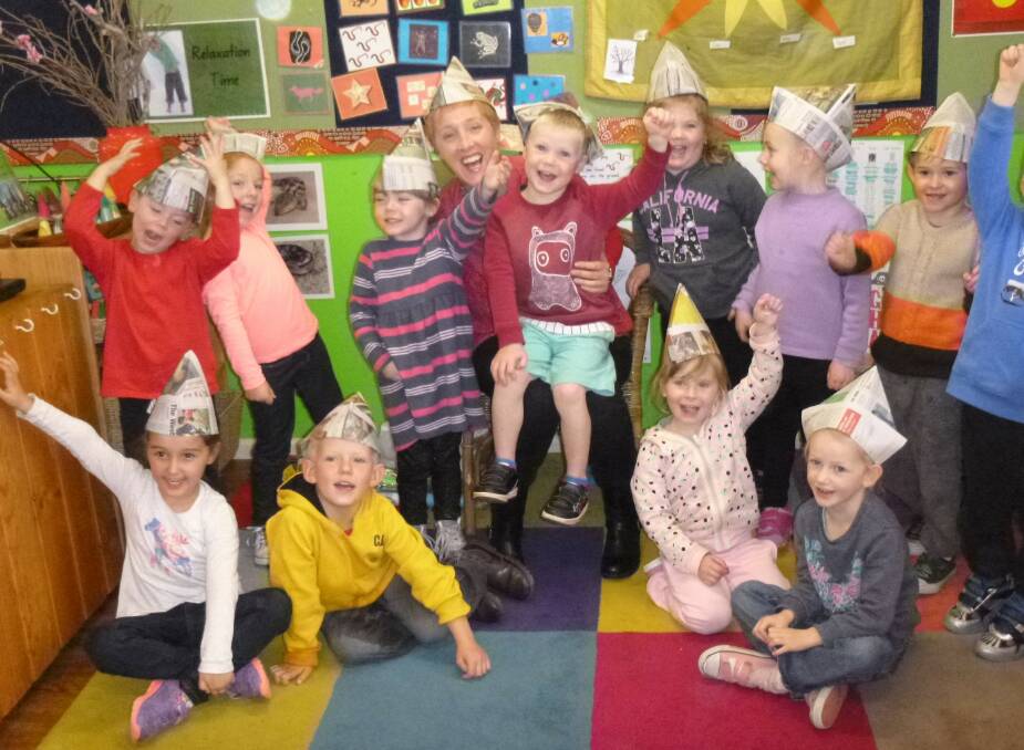 Greer Ashworth with kids from Pied Piper Preschool, wearing hats for National Simultaneous Storytime.
