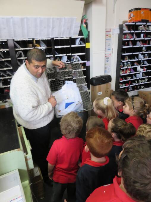 Yashik, the Portland Post Master, explaining to the students how to sort the mail.