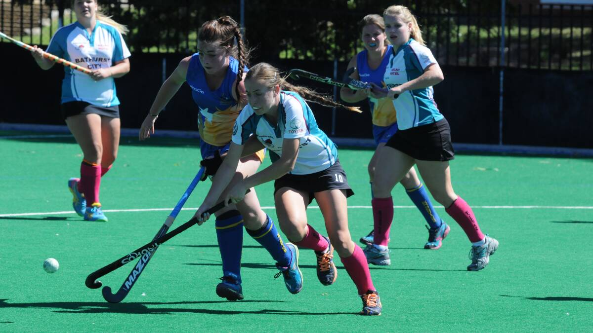 TIGHT TUSSELL: Ex-Services' Madie Smith battles with City's Kelly Baker for the ball in the Bathurst side's 3-0 win. Photo: JUDE KEOGH 0328hockey1