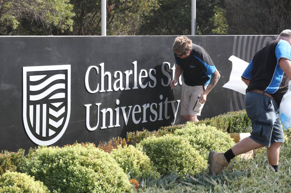 NEW LOOK: Workers installing the new logo sign at Charles Sturt University's entrance in Bathurst on Wednesday morning. Photo: PHIL BLATCH 050119pbcsu1