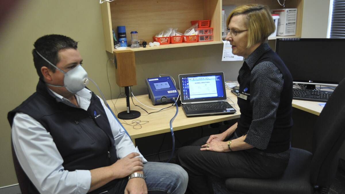 HEALTH CHECK: Malcolm Clift has his mask correctly fitted by CS Health worker Marilyn Davie. 	lm090313CSHealth