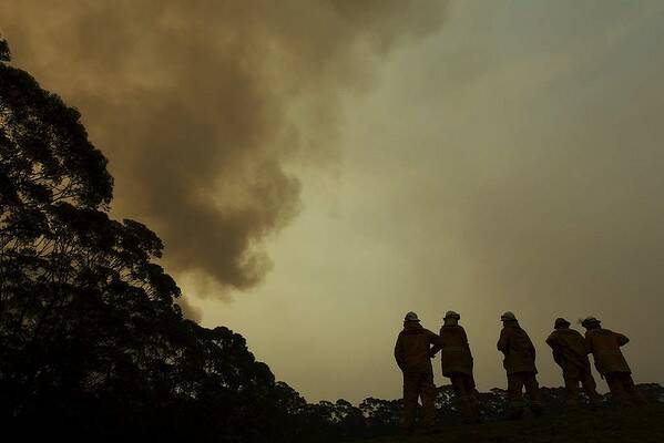 NSW RFS Crews watch the fire front approaching Bilpin behind properties north of the Bells Line of Road. Photo: Wolter Peeters