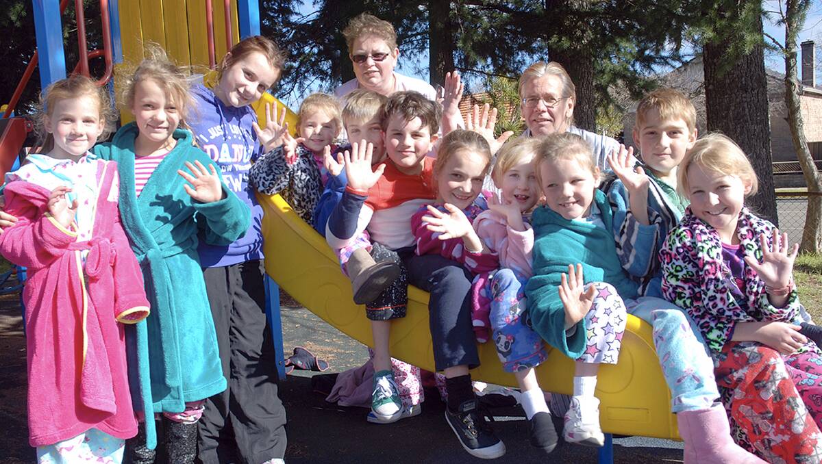 ENJOYING PJs DAY: From left are Amy Luck, Billie and Maddison Boyd, Allirah Northey, Flynn Luck, Francesco Difranco, Muntah Boyd, Ashleigh Hill, Marlee Boyd, James Luck and Maddison Hill; at rear, Vacation Centre’s Theresa Lynch and James Turner.  Photo: JEFF GEDDES	lm071013pjs