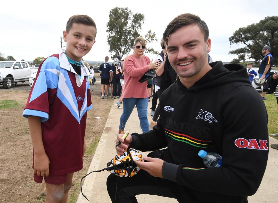 SIGNING: Junior footy player Austin Hanrahan has his head gear signed by Penrith Panthers talent and Lithgow junior Wayde Egan. Photo: CHRIS SEABROOK 050218cpan5