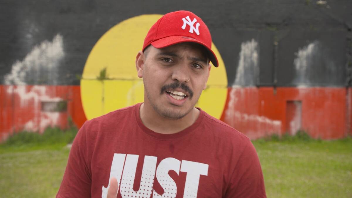 Sonboy, pictured in front of Redfern's flag mural, is featured in the documentary Break It Down Under, by Grant Saunders.