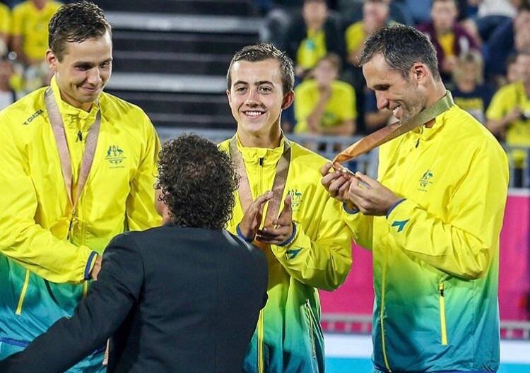 GOLDEN GLOW: Lachi Sharp (centre) proudly showcases his Commonwealth games gold medal with his Kookaburras teammates Mark Knowles (right) and Tom Craig.