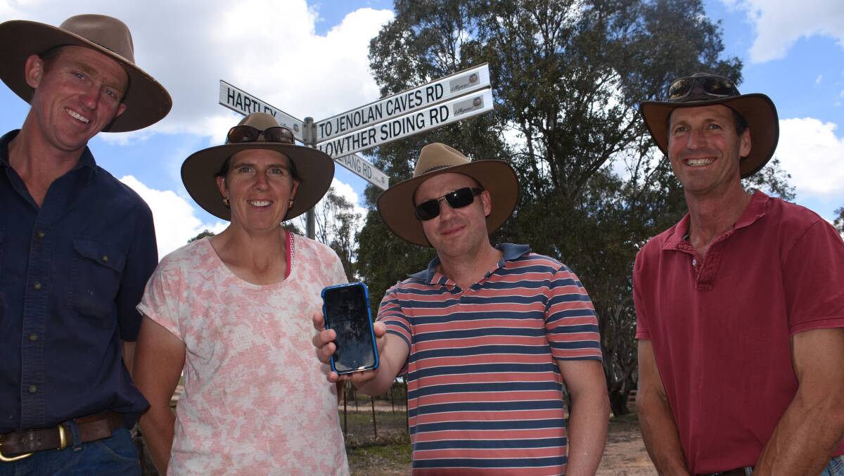 PATCHY: Kanimbla Valley residents Mark Fragar, Tracey and Jason Green and Chris Cox at the one spot you can get reception. Picture: KIRSTY HORTON