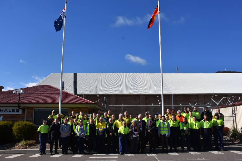 Thales workers stand in front of the Aboriginal and Australian flags, with Mayor Stephen Lesslie and Auntie Helen Riley. 