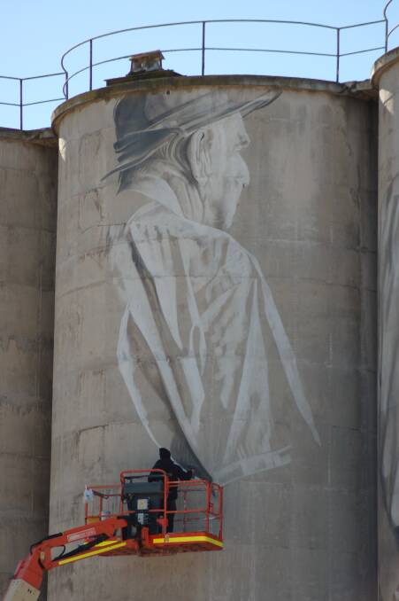 Guido working on the latest portrait on the silos, who is suspected to be related to Councillor Coleman. Picture: CASSANDRA COLEMAN. 