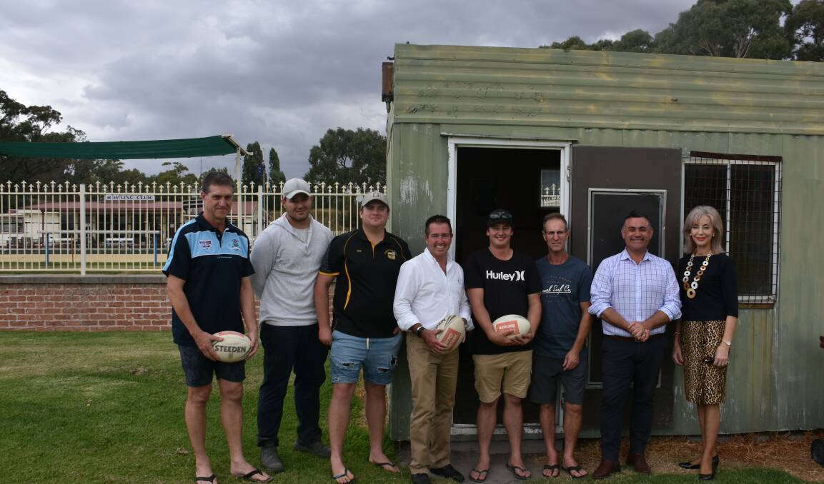 Club members stand with MP Paul Toole and Deputy Premier John Barilaro and counsellor Maree Statham in front of the shack the Touch Football team use as a club house.  