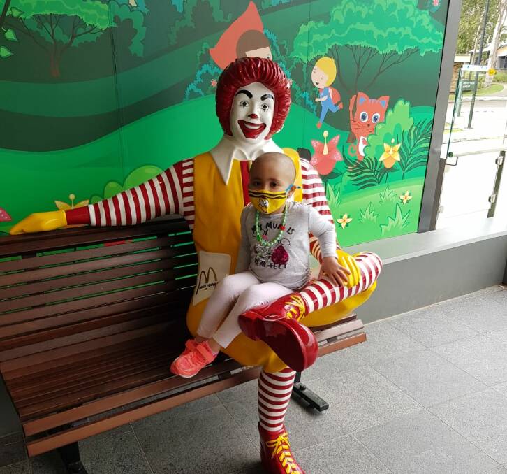 SAFE: Angela Baraz sitting on Ronald McDonald's lap feeling safe at her new home. Photo: SUPPLIED 