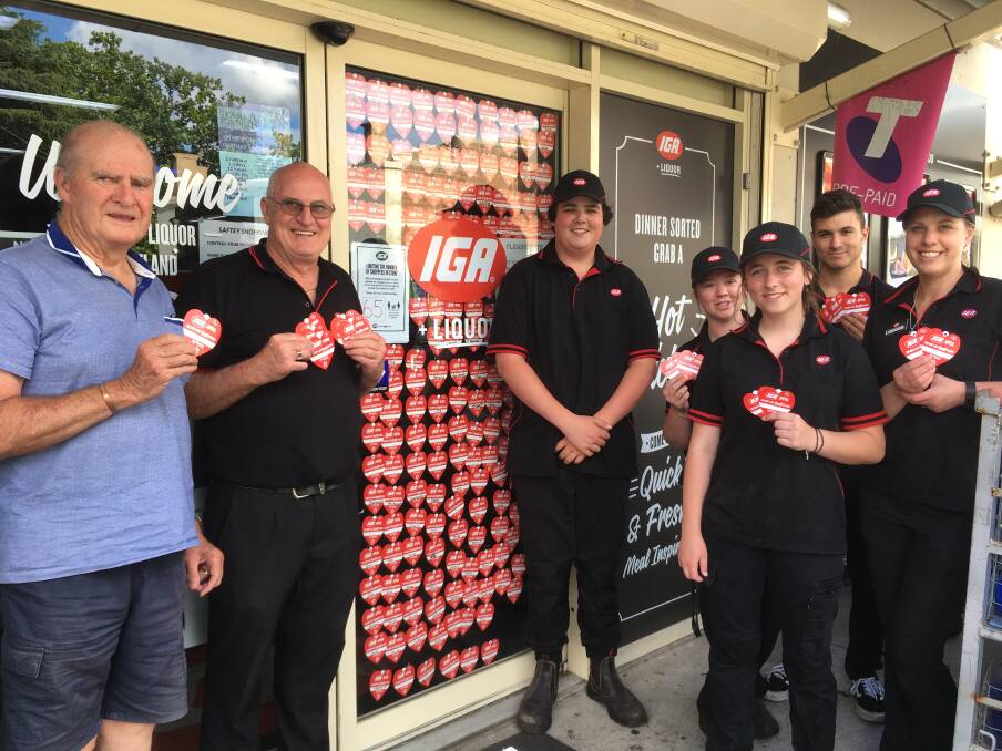 TOGETHER: Store Principal Ian Burke and Staff from Portland IGA Supermarket, with Portland St. Vincent de Paul President John Kearns, displaying the tokens, with those already purchased adorning the front entrance shop window. 