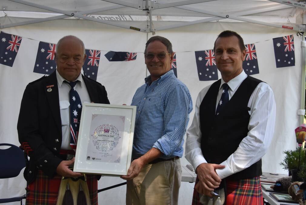 The Highland Pipe Band representatives receive their community service award. 
