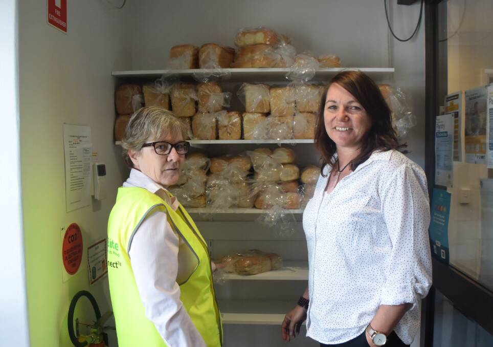Leanne Walding and Sharon Holt stand with the bread that is handed out to residents. 