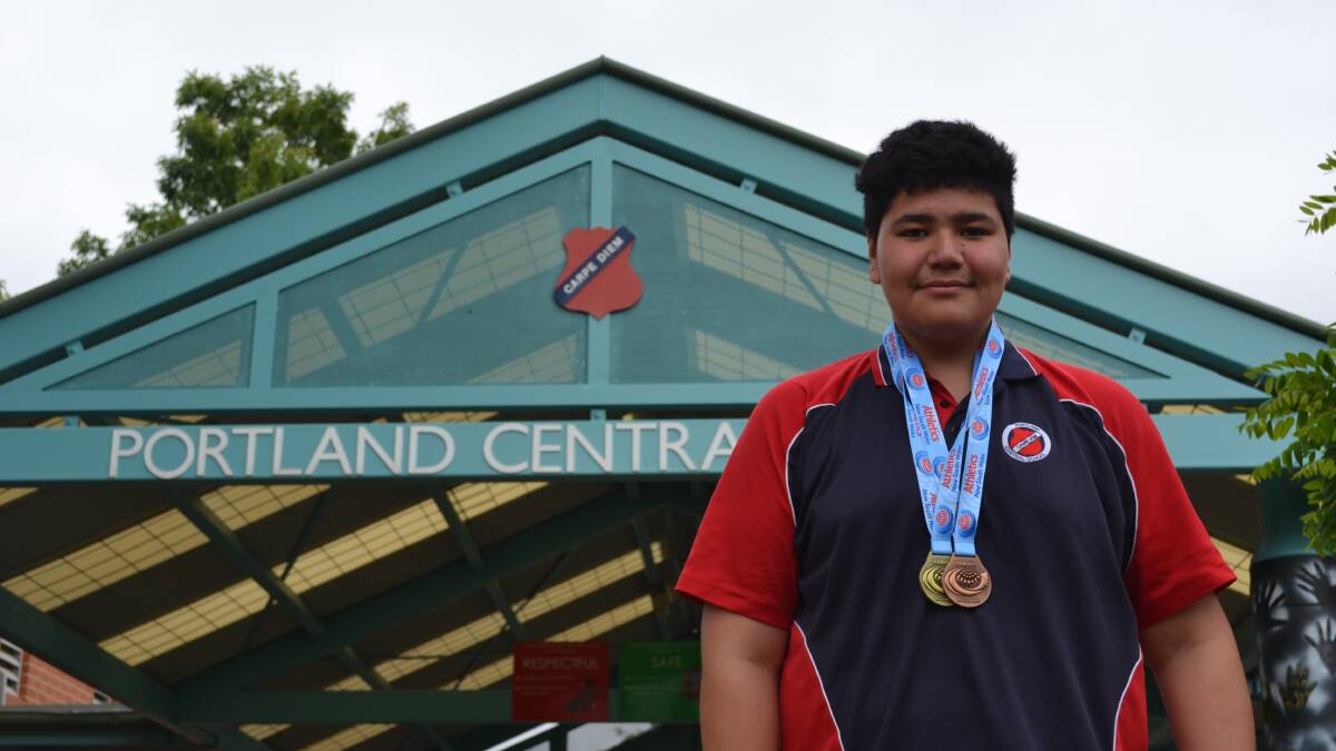 Emeric stands proud in front of Portland Central School with his medals. Photo: CIARA BASTOW 