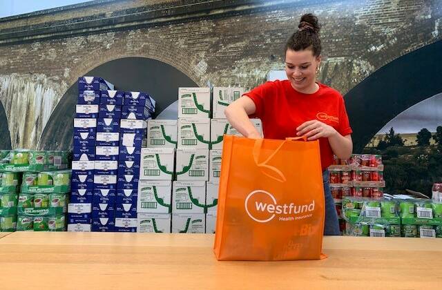 HELPING HAND: Westfunds Marketing Campaign Lead Emma Taylor packed
one of the first hampers for distribution in our local community. 