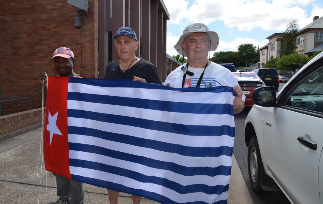 Patianus Kogoya, Roger Bowen and Lithgow's Anthony Craig with the Morning Star flag of West Papua outside the Lithgow City Council. Picture: HOSEA LUY