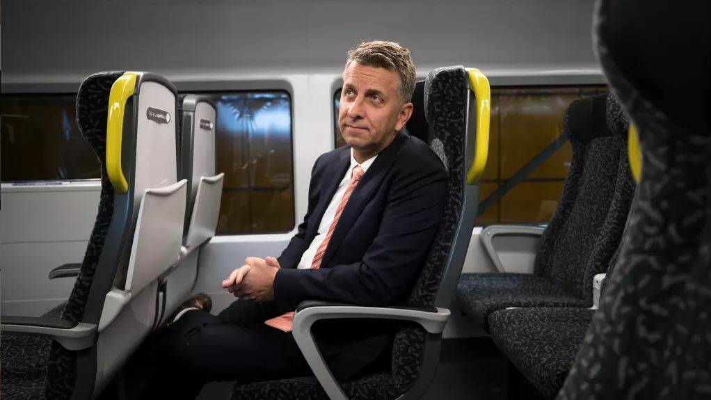 ON BOARD: Transport Minister Andrew Constance on a model of the new fleet, which includes tray tables and phone chargers. Picture: Janie Barrett