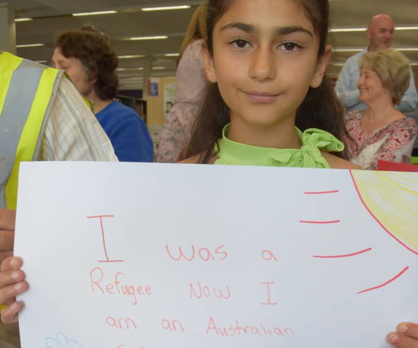 WELCOME: Natalie Mirza with a sign that reads 'I was a refugee now I am an Australian, safe and free." Picture: PHOEBE MOLONEY. 