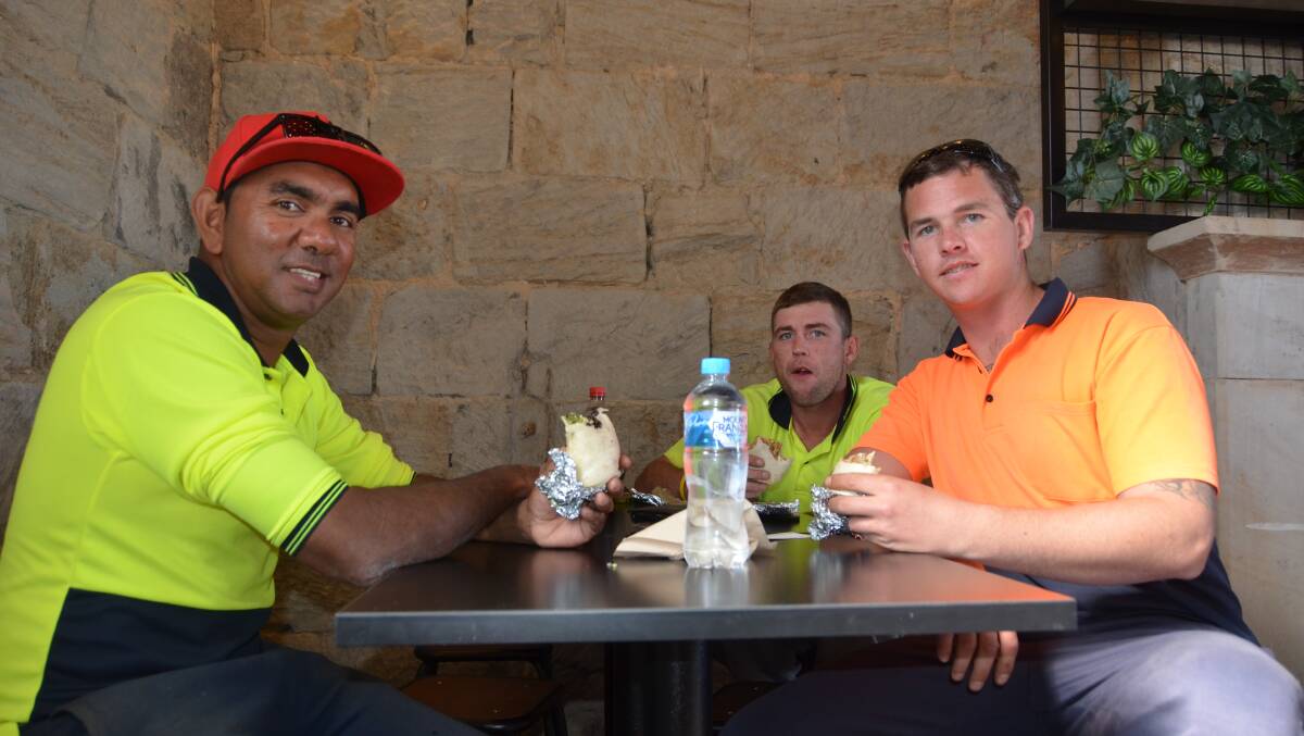 Kel Lampton, Ethan McMullen and Ryan Cook try a burrito on Zambrero's first day of business. 