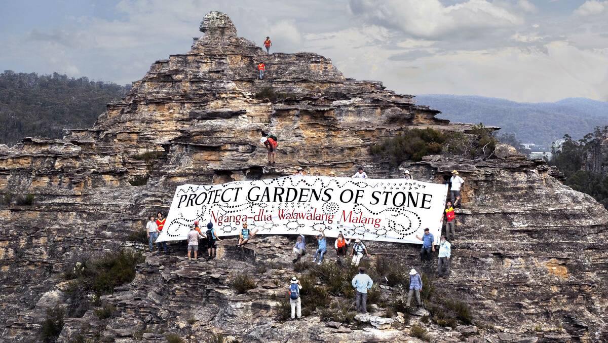 IN ROCK: Environmental campaigners spread banner on rock pagoda in the Gardens of Stone. Picture: HENRY GOLD. 
