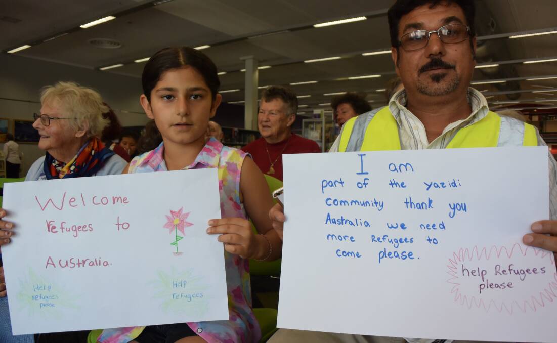 MESSAGE: Natalie and Nawwaf Mirza at the signing. Mr Mirza's sign reads: "I am a part of the Yazidi community thank you Australia we need more refugees to come please." Picture: PHOEBE MOLONEY. 