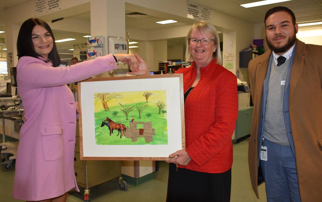 BACK HOME: Operation Art's Heidi Windeisen and Daniel Riger of Westmead Children's Hospital hand over work by Jessica Alexander from Zig Zag Public School to Jill Marjoram. 