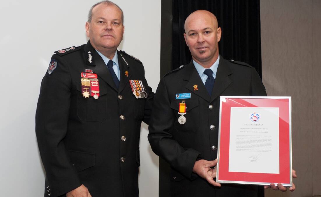 COMMENDATION: Retained firefighter Shane Green receives medal from NSW Fire and Rescue Commissioner Paul Baxter. Picture: SUPPLIED. 