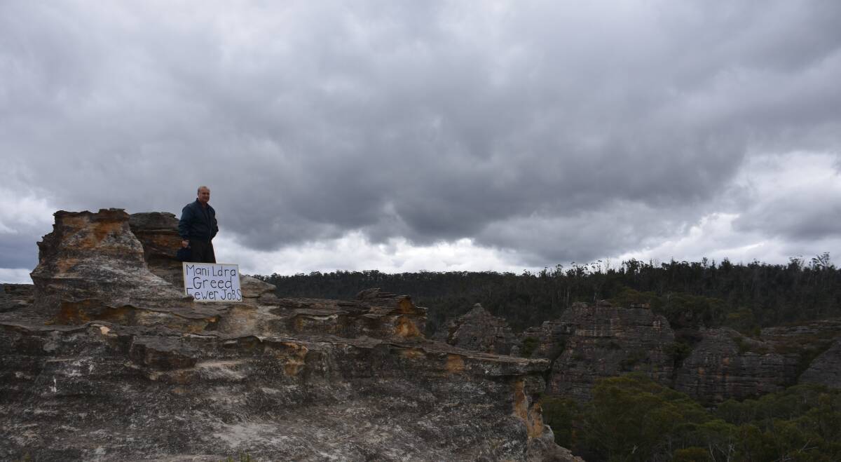 SIGN: Harry Gian of CRUMA stands on a pagoda at Dobbs Drift Lookout. 