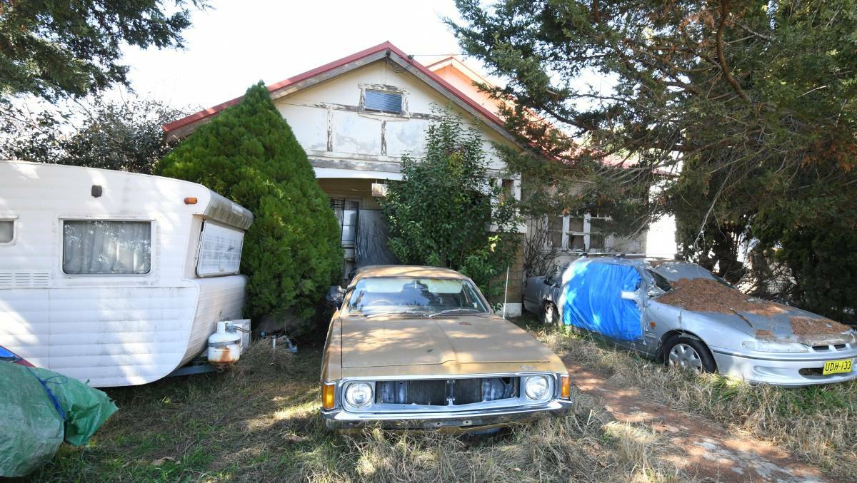 THE WAY IT WAS: The house with old cars and a van in the front yard in August. Photo: JUDE KEOGH