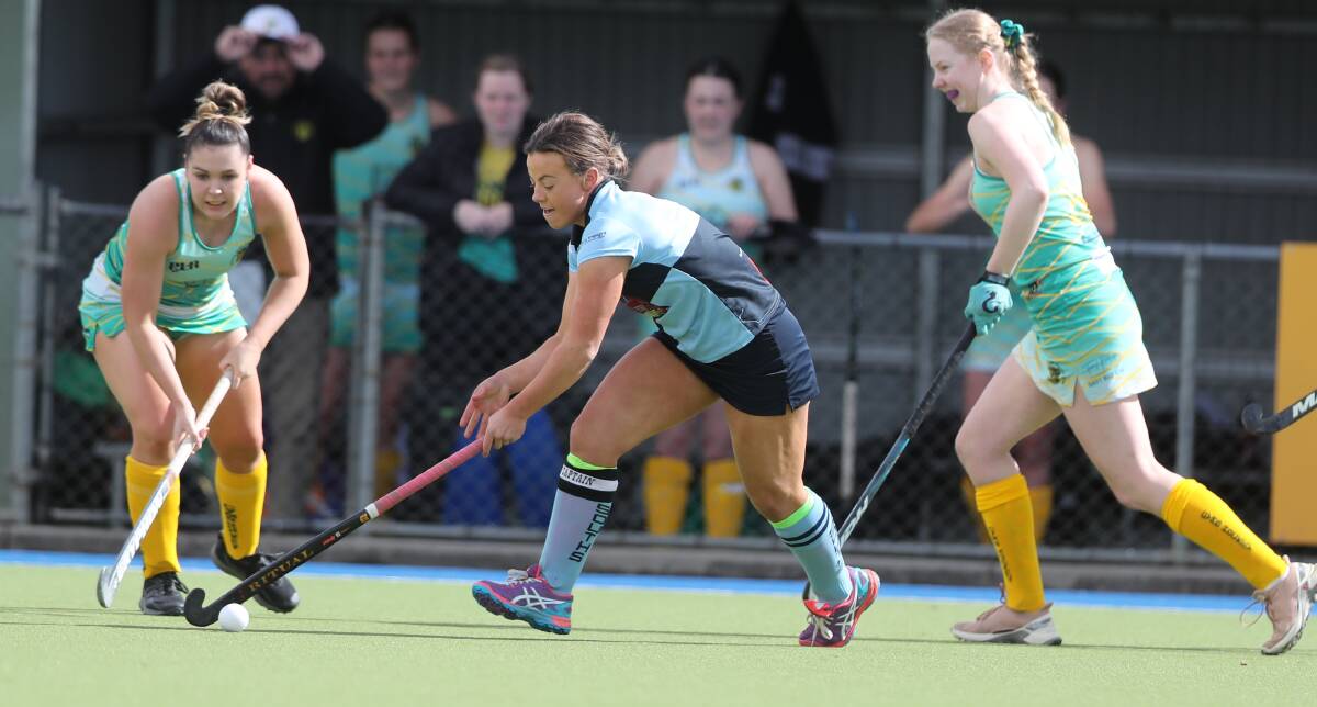 TOUGH DAY: Souths skipper Danielle Fisher tries to work her way around an Orange CYMS rival. CYMS won their Central West Premier League Hockey match 4-1. Photo: PHIL BLATCH
