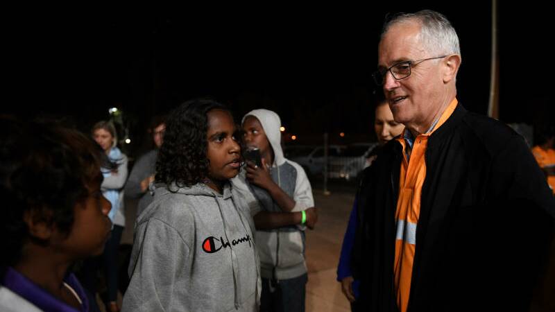 Prime Minister Malcolm Turnbull meets local kids as he rides along in a Julalikari Youth Night Patrol convoy, at Tennant Creek, in the Northern Territory. Photo: AAP Image/Dan Himbrechts